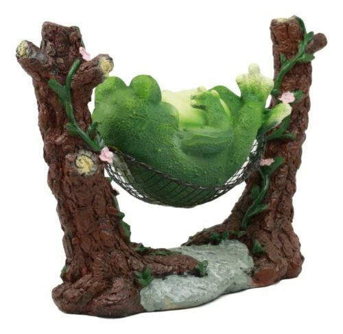 Estatua de rana gorda caprichosa durmiendo en una hamaca para un cuento de hadas.-2
