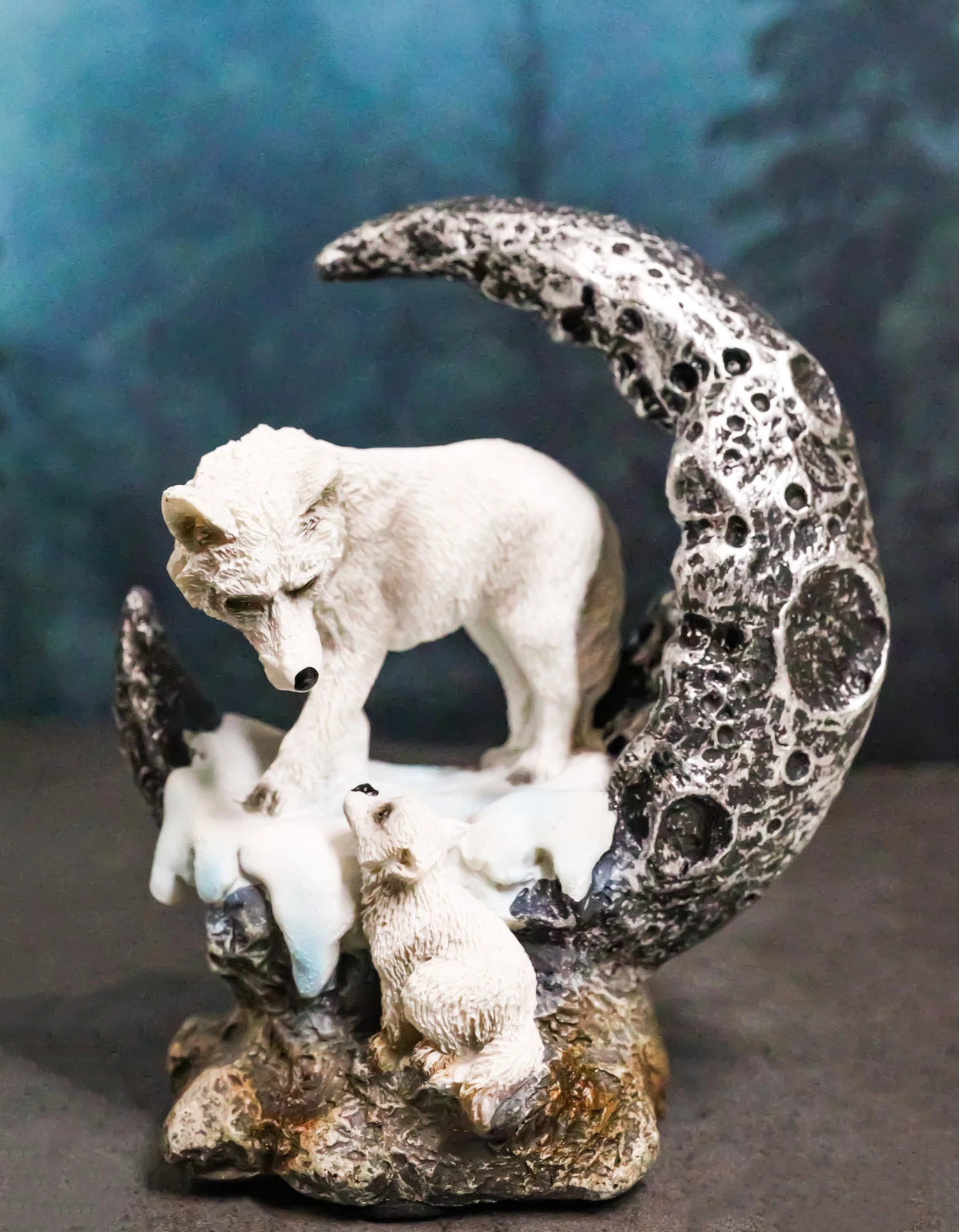 Figura de luna creciente de una loba blanca como la nieve con su cría en un cráter nevado