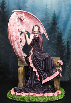 Elegante estatua de dragón wyvern rosa con hada rosa con vestido negro sentada en un banco-1